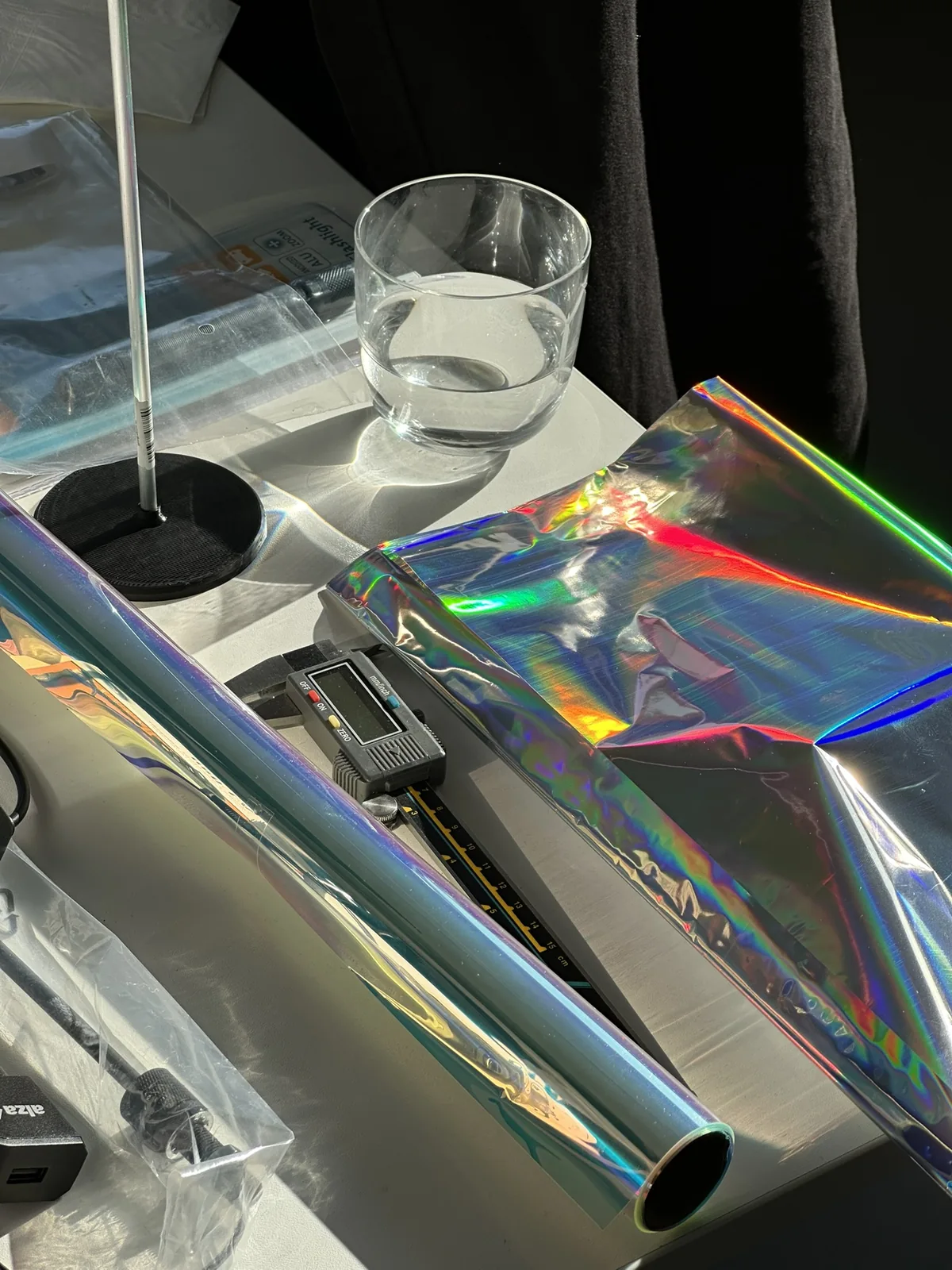 Detail tvůrčí práce: kov, průhledné materiály a duhové odlesky